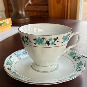 Teacup and saucer with blue flowers.
